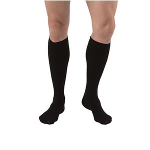 Person wearing black knee-high compression socks for medical support