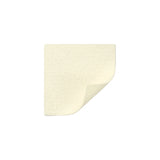 Square beige medical adhesive foam dressing with one corner slightly lifted