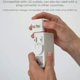 Hands holding a medical device power adapter with removable US plug, white background