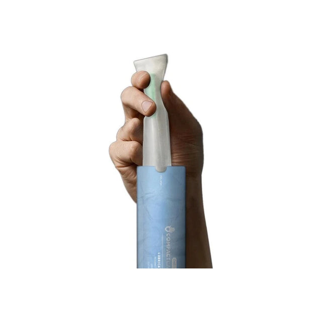Hand holding a CompactCath hydrophilic intermittent catheter in blue packaging
