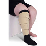 Compression leg wrap for edema or lymphedema on lower leg, person seated on stool