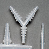 Clear plastic Y-shaped barbed medical tube connector on gray background