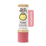 Tinted sunscreen lip balm stick labeled Sunset Cove, SPF 15, white and pink packaging