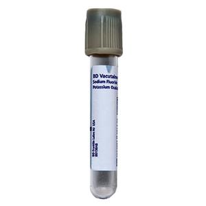 Empty medical blood collection tube with grey cap and labeled for laboratory use