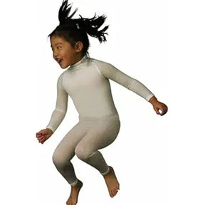 Child wearing full-body white medical compression suit, jumping, on plain background