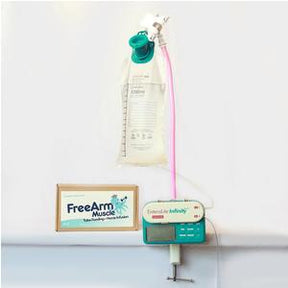 Enteral feeding pump with fluid bag, pink tubing, and FreeArm Muscle sign on white wall