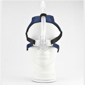 CPAP nasal mask with headgear and hose on white mannequin, medical sleep apnea aid