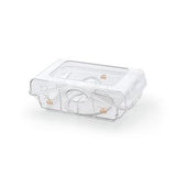 Clear plastic CPAP humidifier water chamber on white background, medical supply accessory.