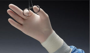 Gloved hand in medical gown holding surgical scissors, sterile medical supplies