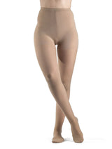 Woman wearing sheer honey-colored compression pantyhose, full length on white background
