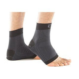 Close-up of feet wearing black compression ankle sleeves for support and pain relief