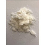 Close-up of white crystalline medical powder on a plain surface
