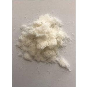 Close-up of white crystalline medical powder on a plain surface