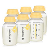 Six Medela breast milk storage bottles with yellow lids and measurement markings