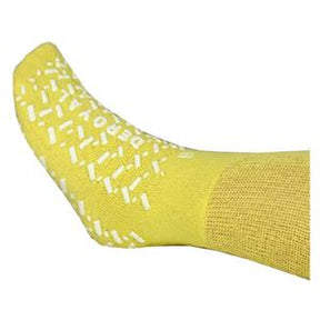 Yellow non-slip hospital sock for medical use, close-up of foot with rubber grips