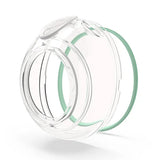 Clear reusable breast pump cup with green silicone ring on white background