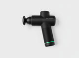 Black handheld percussion massage gun with green accent on white background