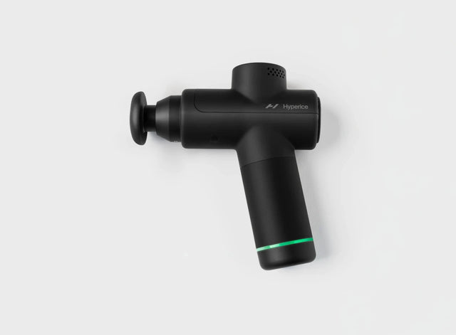 Black handheld percussion massage gun with green accent on white background