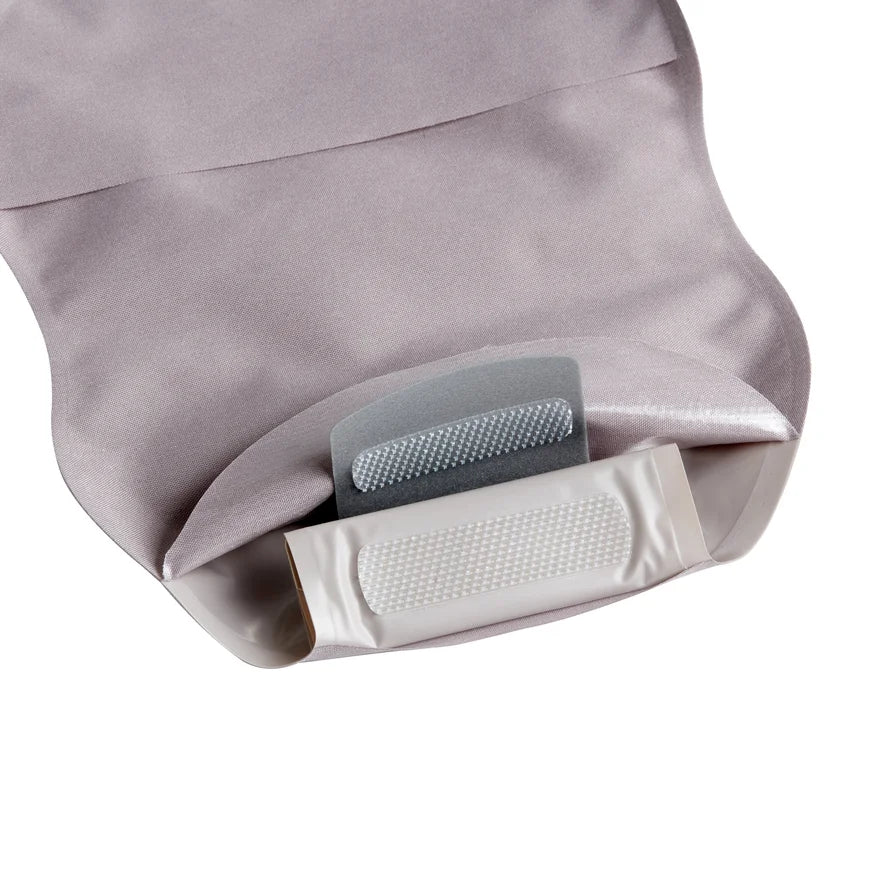 Close-up of a beige medical ostomy bag with adhesive closure and soft fabric cover