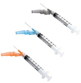 Three medical syringes with colored needle caps on a white background