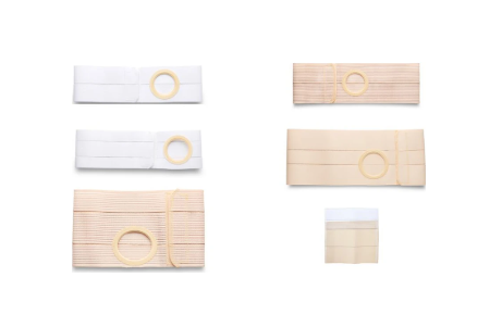 Various ostomy belts in white and beige with circular openings, arranged on a white background.