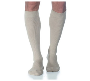 Beige knee-high compression socks worn on legs, medical support hosiery