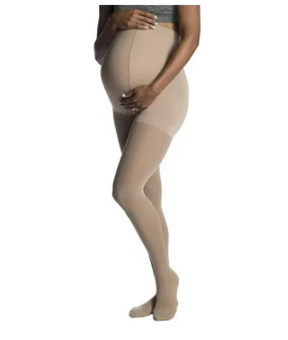 Pregnant woman wearing beige maternity compression stockings