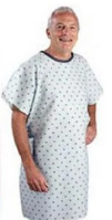 Smiling man wearing a light blue patterned hospital gown against white background