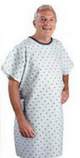 Smiling man wearing a light blue patterned hospital gown against white background