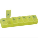 Yellow weekly pill organizer with compartments labeled for each day