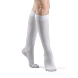 White knee-high compression socks on legs, medical support hosiery for women