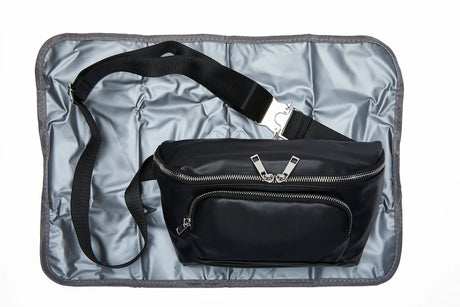 Black medical supply waist bag with zipper pockets and adjustable strap on a padded mat