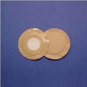 Two round beige medical adhesive bandages on a blue surface