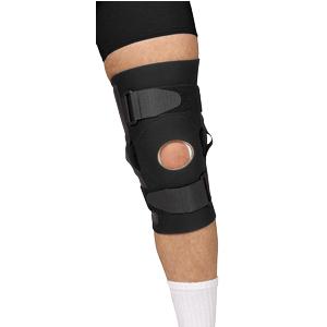 Adjustable black knee brace with open patella on person's leg, medical support device