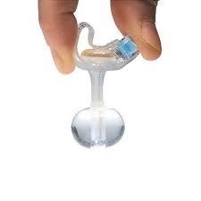Hand holding a transparent medical balloon catheter with blue safety feature on white background.