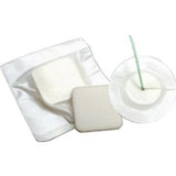 Sterile white medical foam dressing pad on packaging and with wound care supplies