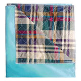 Plaid waterproof medical bed pad with blue backing, folded for home healthcare use