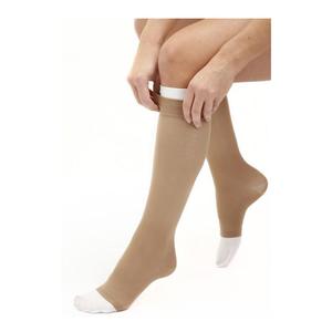 Person wearing beige knee-high compression socks for medical support