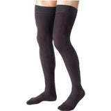 Black thigh-high compression stockings on legs, medical support hosiery for adults