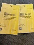 Two Protege xeroform petrolatum gauze dressing packs on a textured surface, medical supplies