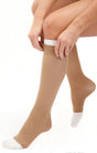 Person putting on beige knee-high compression socks with white toes for medical support
