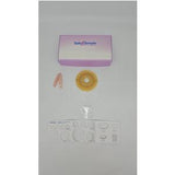 Ostomy care starter kit with barrier ring, measuring guide, and pink clamp on white background