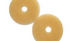 Two round beige medical adhesive barrier rings on white background, ostomy supplies