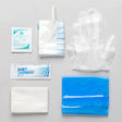 Disposable medical supply kit with gloves, alcohol pad, gauze, and sanitary wipes on gray background