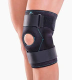 Adjustable neoprene knee brace with patella support on a person's leg