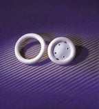 Two white medical rings on a purple surface, one solid with holes, for medical supply use