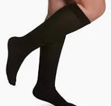 person wearing black knee-high compression socks for medical support