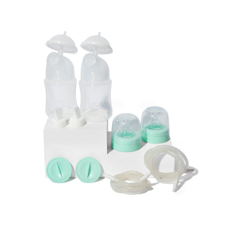 Breast pump supply kit with bottles, tubes, lids, and caps on white background