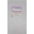Ostomy care kit with barrier ring, stoma measuring guide, and medical supplies on white background