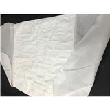 Disposable white medical bed sheet on black surface, home healthcare supply